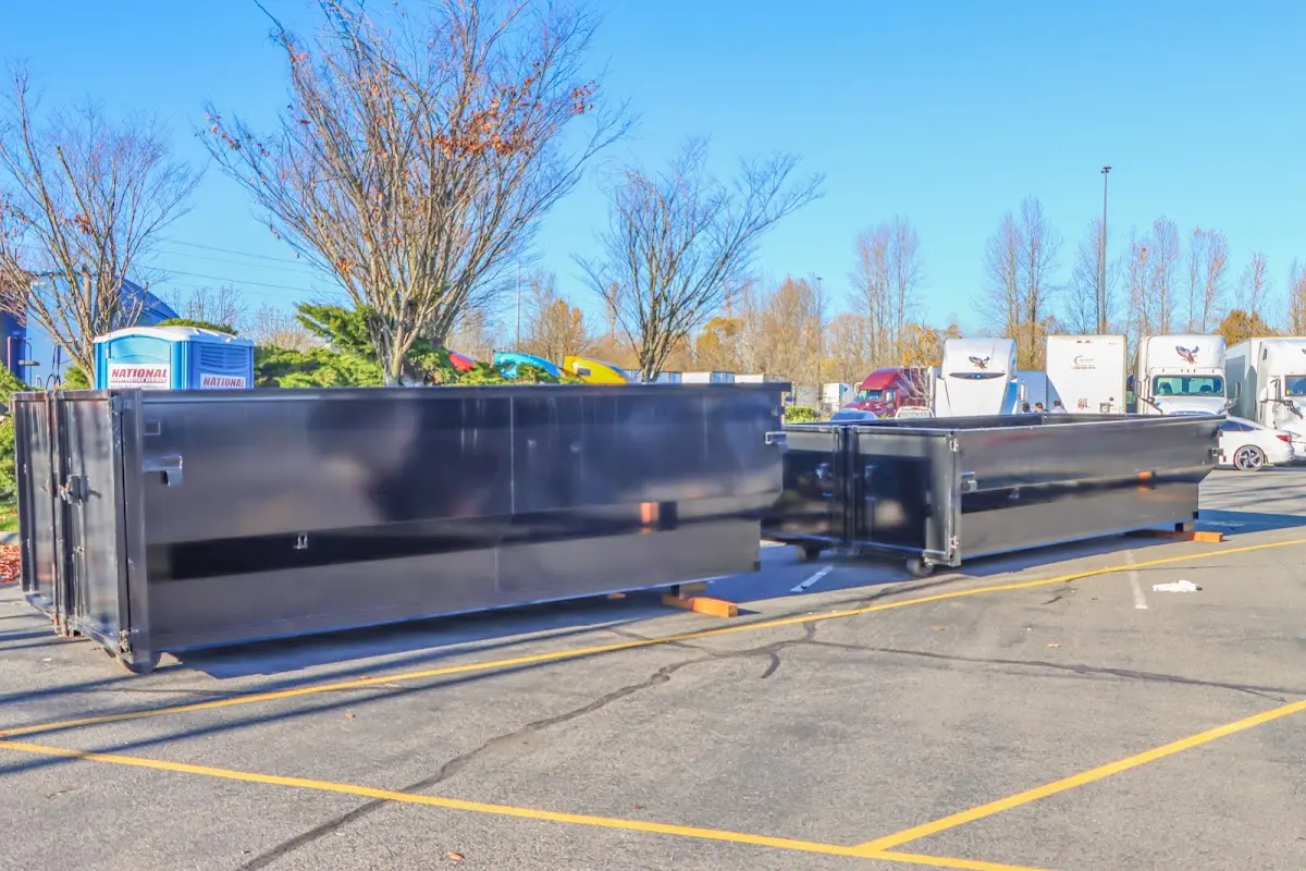 Professional dumpster rental service with roll-off container on residential driveway in Melrose